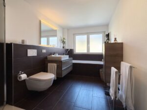 Elegantes Tageslichtbad mit bodengleicher Dusche und Badewanne