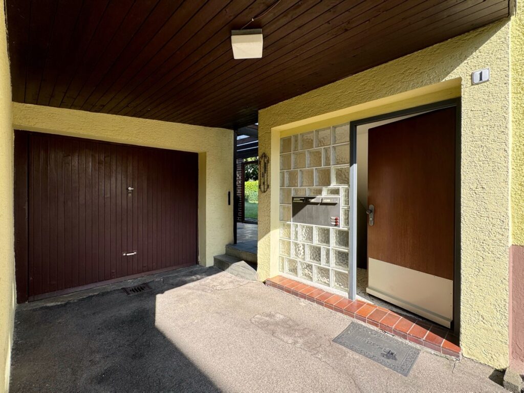 Einfahrt mit Blick auf den Eingang, das Gartentor und die Garage