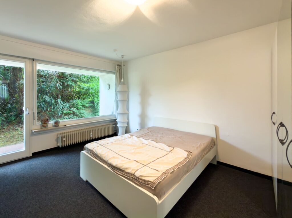 EG-Schlafzimmer mit Zugang auf eine überdachte Terrasse